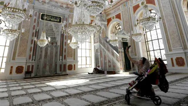 ایک خاتون سیاح اپنے بچے کے ساتھ ترکی کی اورتکوئے مسجد میں اپنی سیلفی( کیمرے سے اپنی تصویر) لے رہی ہیں۔ 