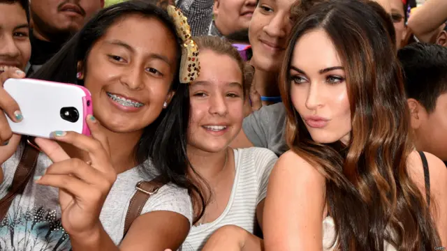 کیلیفورنیا کے علاقے ویسٹ وڈ میں انگریزی فلم ’ٹین ایج میوٹنٹ ننجا ٹرٹلز‘ کے پریمیئر کے موقعے پر ایک مداح اداکارہ میگن فوکس کے ساتھ سیلفی کھینچ رہی ہے۔