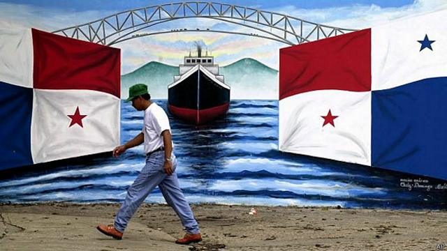 Hombre camina ante mural con bandera panameña