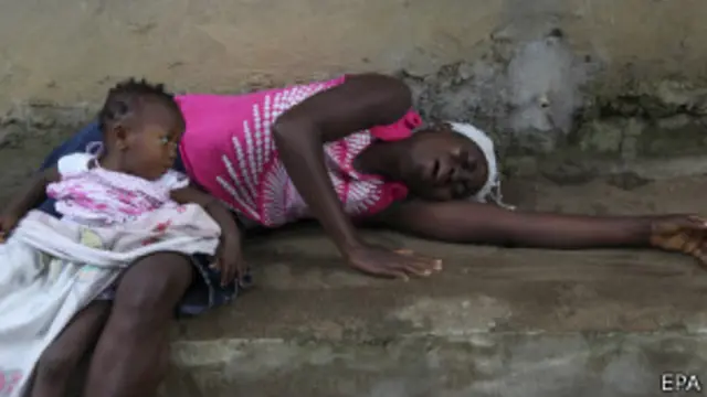 Mujer llora a pariente fallecido por ébola.