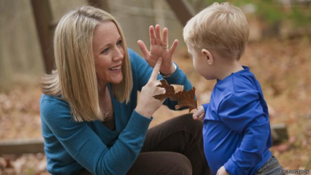 Mujer utilizando lenguaje de signos con niño.
