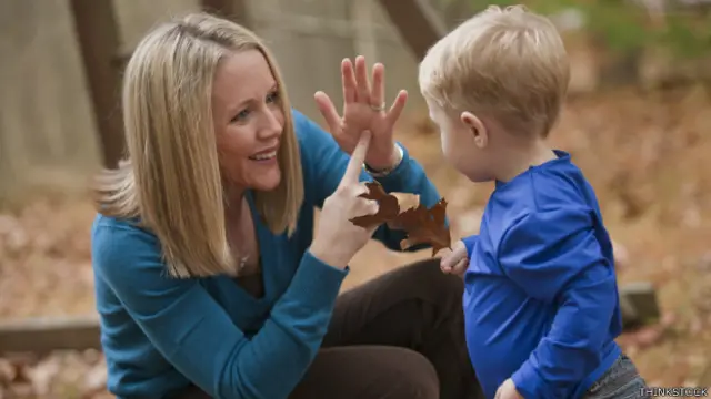 Mujer utilizando lenguaje de signos con niño.
