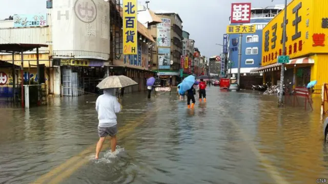 高雄氣爆災區居民涉水通過淹水街道(台灣中央社圖片11/8/2014)