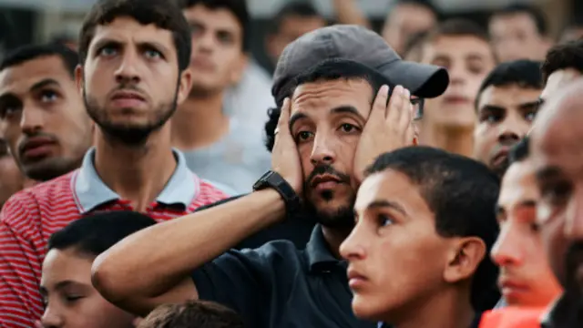 فلسطينيون يتابعون احتراق مصنع للصابون في غزة عقب قصف إسرائيل له.