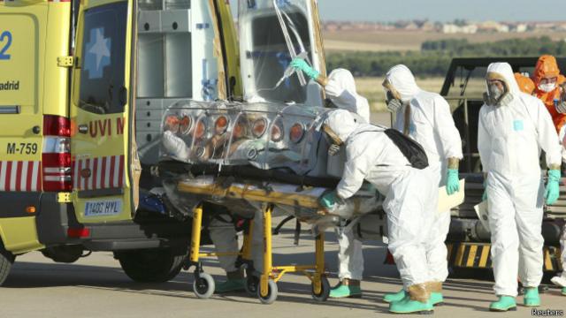 Заразившегося вирусом Эболы священника транпортируют в машину "скорой помощи" в Мадриде