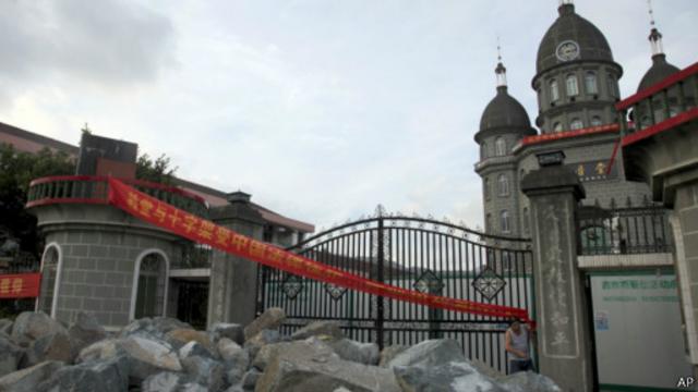 信徒们在温州平阳县的教堂前堆起石头，阻止拆除十字架行动。