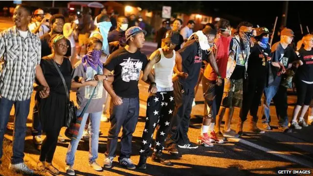 示威者高喊「舉手投降，不要開槍」的口號，但是警察的高音喇叭要求人群散離。