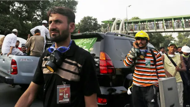 عوامی تحریک کے کچھ کارکن گیس ماسک بھی گلے میں لٹکائے دکھائی دیے۔