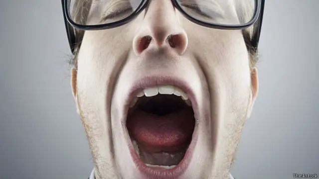 Мужчина в очках зевает