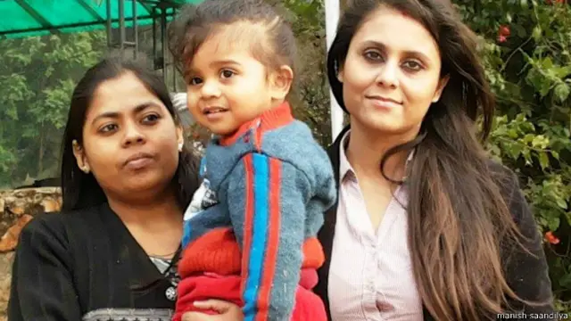 गुड़िया इस तस्वीर में असम बाल संरक्षण समिति में काम करने वाली नीलाक्षी शर्मा के साथ दिख रही है.