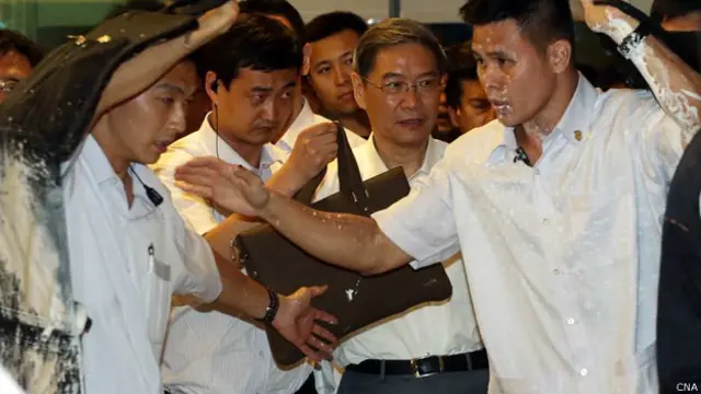 高雄中山大學內維安人員阻擋張志軍(前右二)免受潑漆攻擊(台灣中央社圖片27/6/2014)