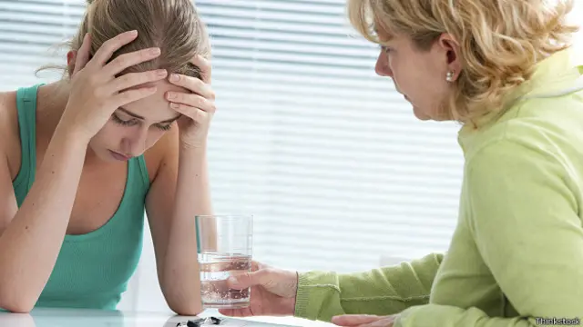 Подавленной девушке предлагают стакан воды