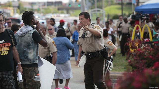 Manifestante y policía en Ferguson