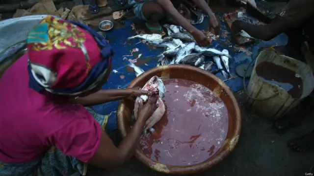 Mujer limpiando pescado