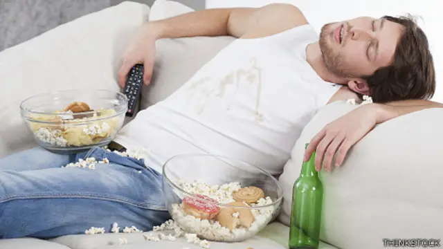 Hombre dormido en el sofa con comida