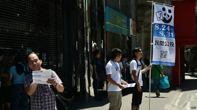 澳門水坑口公共行政大樓外兩名民間投票志願者派發宣傳單張（24/8/2014）