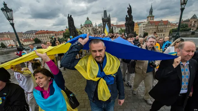 День незалежності України святкували і в багатьох інших країнах - зокрема, Польщі, Чехії та Голландії. На фото - українці несуть свій прапор по Карловому мосту в Празі.