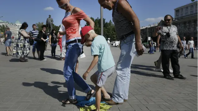 Люди топчуть український прапор в Донецьку.