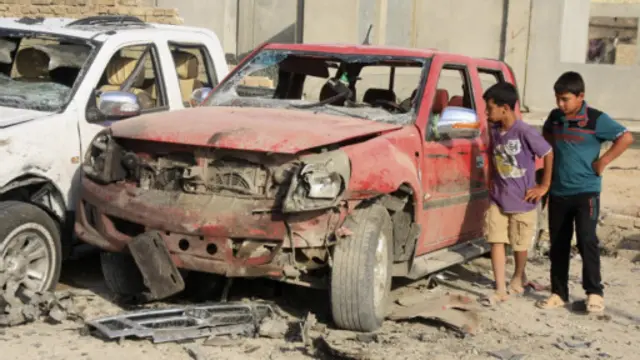 طفلان يتفقدان الاضرار التي لحقت بسيارة في تفجير بكربلاء الاثنين