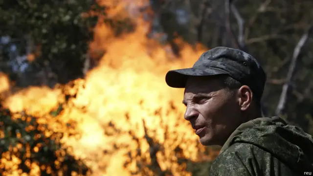 Про-российский боевик у горящего газопровода в Донецке 