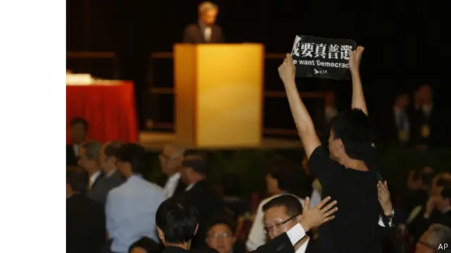 ماموران امنیتی در حال بیرون بردن یکی از معترضان از سالن