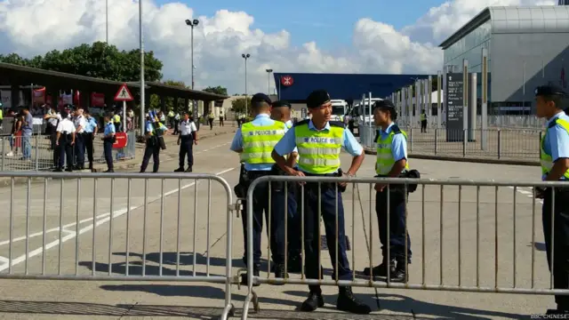 警员在香港亚洲国际博览馆外监视敌对示威者（BBC中文网图片1/9/2014）