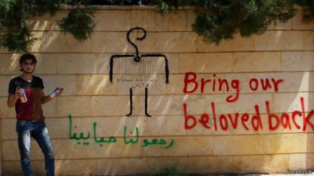 صورة من صفحة الحملة على فيسبوك تظهر متضامن من داخل سوريا، بجانب غرافيتي يروج للحملة.