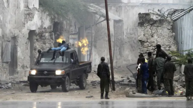 جندي صومالي يواجه بعض من يشتبه بأنهم أعضاء في حركة الشباب قرب مقديشو.