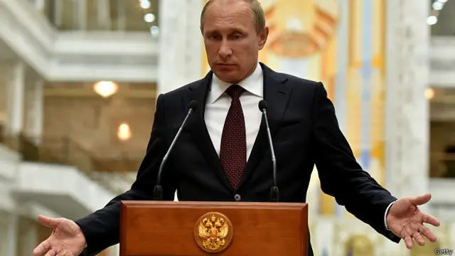 Tổng thống Putin đeo cà vạt đỏ sẫm. Đỏ là màu được xem là biểu hiện quyền lực.