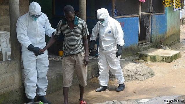 Enfermeros ayudan a paciente de ébola