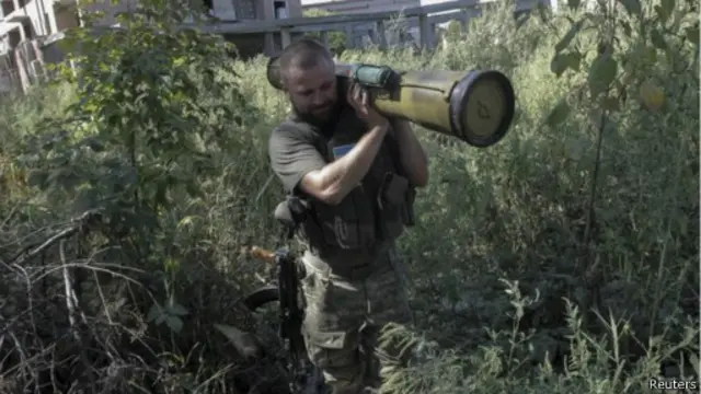 شرطي أوكراني يزيل سلاحا وجد في منطقة سلوفيانسك، بمنطقة دونيتسك، يوم الثلاثاء