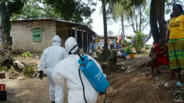 العاملين في مكافحة المرض يحملون أنابيب