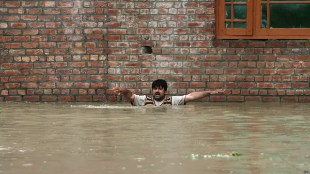 श्रीनगर में बाढ़ के पानी में घिर जाने के बाद मदद की अपील करता एक व्यक्ति.