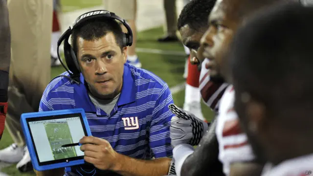 Kevin Gilbride, de los Gigantes de Nueva York, explica a través de una tableta la estrategia a seguir.