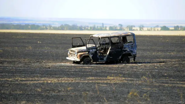 Сгоревший автомобиль в поле под Мариуполем