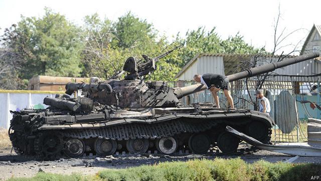 Жители деревни под Мариуполем осматривают подбитый танк