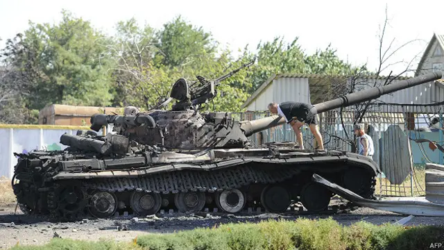 Жители деревни под Мариуполем осматривают подбитый танк