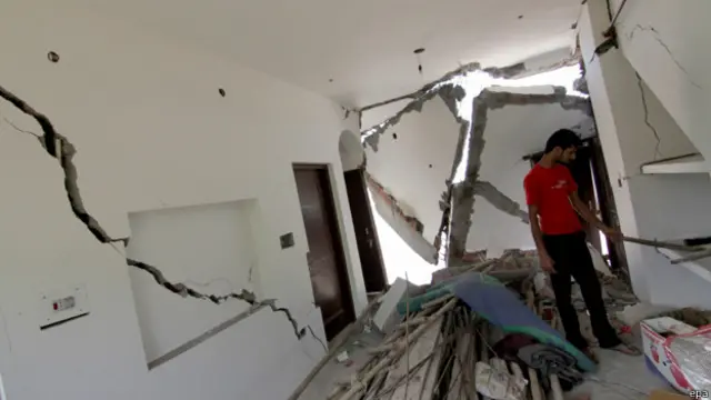 कश्मीर में बाढ़ से कई घर टूट भी गए हैं. अपने घर का मुआयना करता एक व्यक्ति.