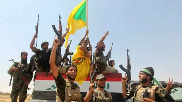 مقاتلو ميليشيا شيعية يحتفلون بانسحاب متشددي تنظيم الدولة الإسلامية على الطريق بين آمرلي وتكريت