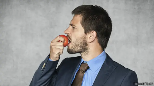 Ejecutivo comiendo una manzana