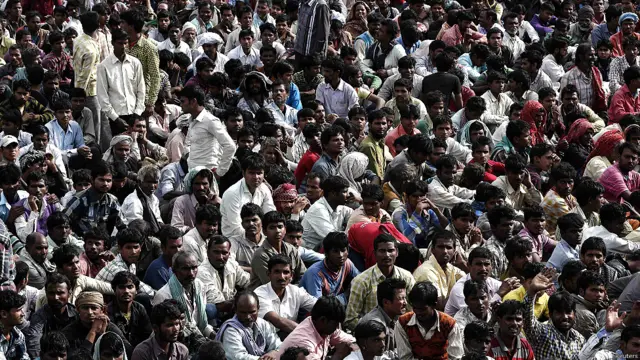 श्रीनगर के हवाई अड्डे पर अपने घर की ओर लौटने के इंतजार में बैठे प्रवासी मज़दूर.