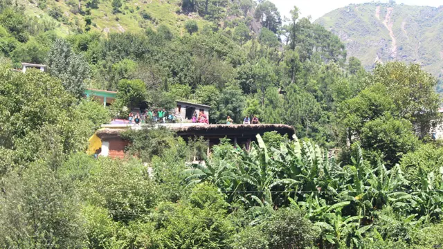 रजौरी ज़िले के एक गांव में अपने घर की छत पर बैठे लोग.