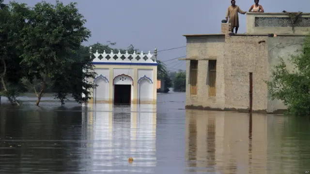 ضلع جھنگ کا بیشتر علاقے زیر آب آ گیا جہاں ایک چھت اور دو افراد مدد کے انتظار میں۔