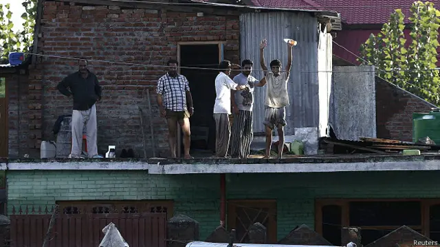 श्रीनगर में अपने घर की छत से मदद की अपील करते लोग