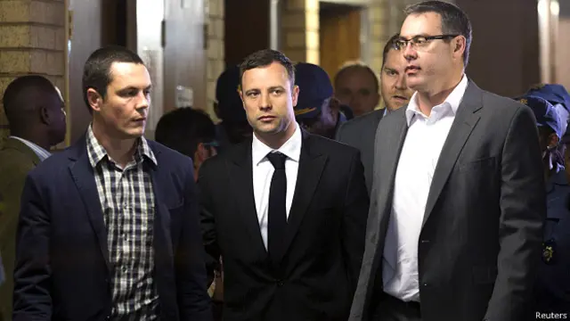 अदालत में जाते ऑस्कर पिस्टोरियस (बीच में)