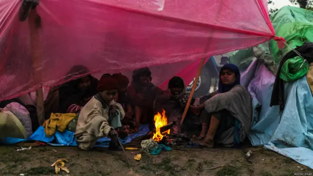 ایک اور خاندان کے لوگ محفوظ مقام پر پہنچ کر سردی سے بچنے کے لیے آگ جلا کر سینک رہے ہیں۔