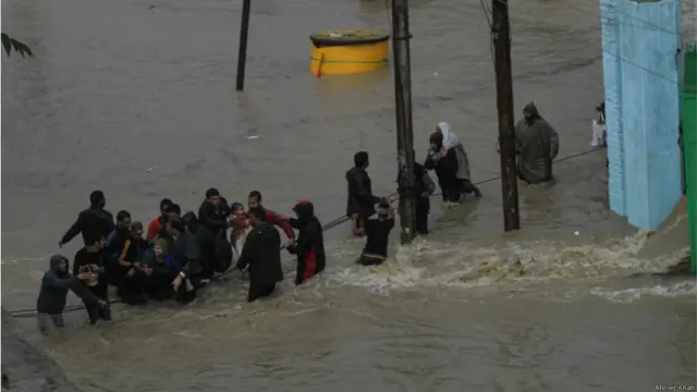 سری نگر کے علاقے نوگام میں لوگ ایک عمر رسیدہ خاتوں اور بچے کو بچا کر لیجا رہے ہیں۔