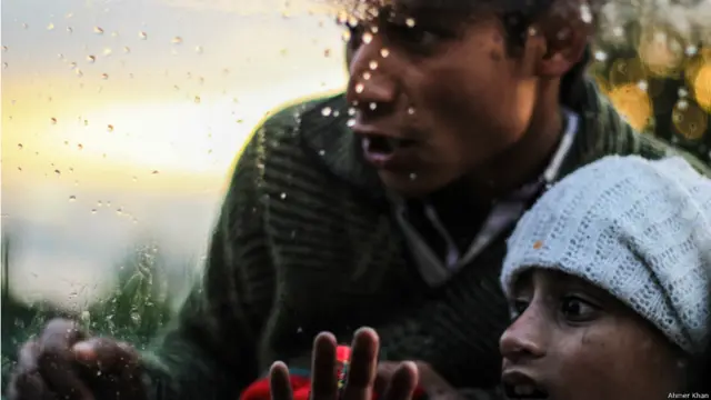 سری نگر کے علاقے حیدر پورہ میں امداد کے منتظر بچے ایک گاڑی جس میں امدادی سامان لایا گیا اس کے شیشے کے باہر سے دیکھ رہے ہیں۔