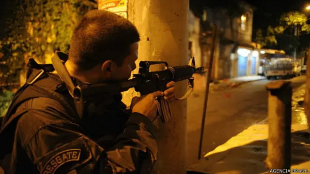 Policía apunta su fusil en una comunidad de Río de Janeiro.