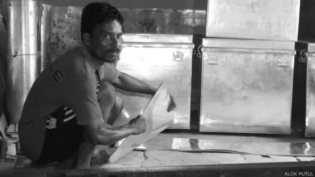 टिन के बक्से बनाता कारीगर